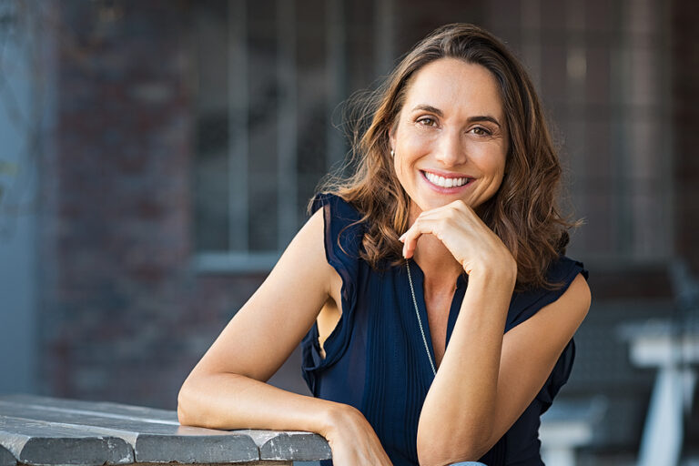 Portrait of beautiful mature woman sitting at coffee shop. Happy